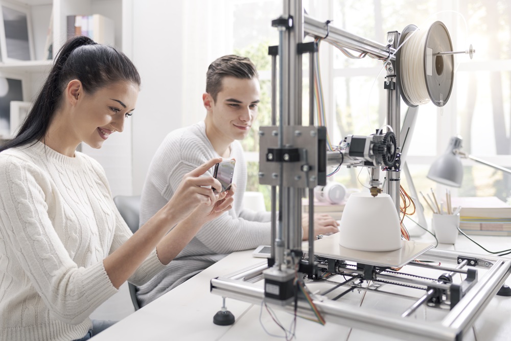 Academic students using a 3D printer in the lab